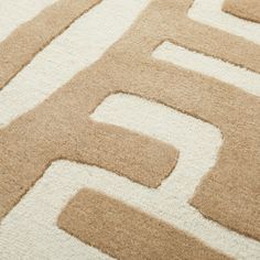 a beige and white rug with the letter e on it's center, surrounded by smaller letters