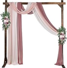 a pink and white wedding arch decorated with flowers