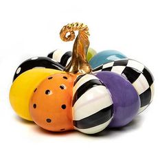 an assortment of colorful ceramic balls with a gold figurine in the middle on a white background