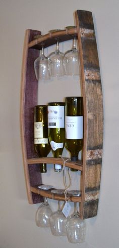 wine glasses and bottles are sitting on a wooden shelf with two racks holding wine glasses