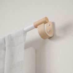 a white curtain with a wooden handle attached to it