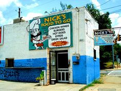 a blue and white building with a sign for nick's food to go on it