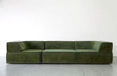 a green couch sitting on top of a white floor