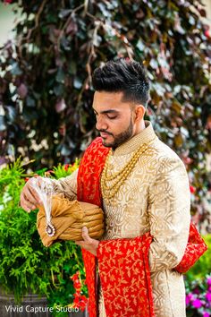 a man in a red and gold outfit is holding a piece of bread while looking down at it