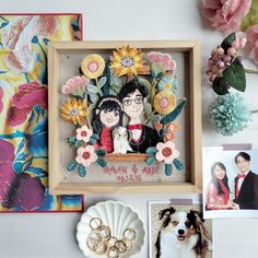 an image of a couple and their dog in a frame with flowers on the wall