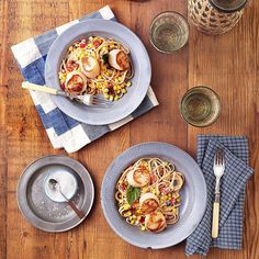 two plates of food on a table with utensils and napkins next to them