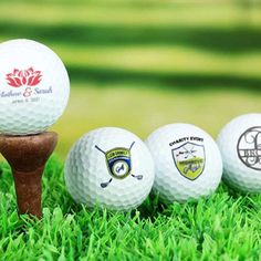 three golf balls sitting on top of a wooden tee in the grass next to each other