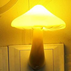 a yellow lamp sitting on top of a wall next to a white light switch box