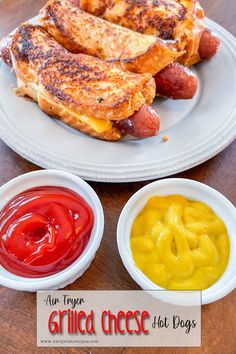 grilled cheese hot dogs with mustard and ketchup on a plate next to two small bowls