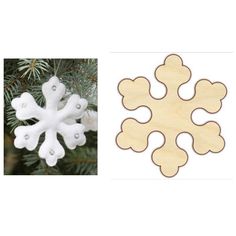 a wooden snowflake ornament next to a pine tree with white ornaments