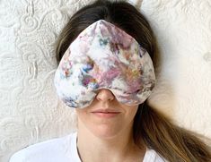 a woman wearing a white t - shirt and a tie dyed sleep mask