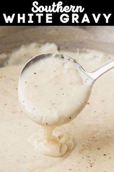 a spoon full of white gravy being held over the top of a pot