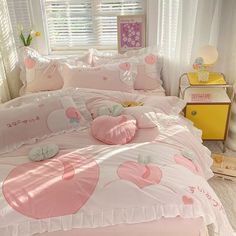 a bed with pink and white comforters in a bedroom next to a window,