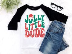 This trendy retro Christmas shirt is a must have for your Jolly Little Dude to rock this Christmas Holiday Season. Available in the black and white raglan shirt, or black or white tee shirt and bodysuits. ✨ HOW TO ORDER ✨ ✧ Select your options from the Drop Downs ✧ ADD TO CART • • • • • • • • • • • • • • • • • • • • • • • • • • • • • 👕 TOPS 👕 ✧Raglan shirt - soft black and white ✧Bodysuit - soft jersey rib knit bodysuit with envelop neck opening for easy on and off • • • • • • • • • • • • • • • • • • • • • • • • • • • • • 🎨 GRAPHIC DETAILS 🎨 ► Professional and Permanent Quality ► Vibrant and Accurate colors • • • • • • • • • • • • • • • • • • • • • • • • • • • • • 📋 CARE INSTRUCTIONS 📋 ✧ Wash Gentle ✧ No Bleach or Bleach Substitutes ✧ Hang to Dry for longevity ✧ Do not Iron Toddler Christmas Shirts Boy, Christmas Shirts For Boys, Hipster Toddler Boy, Christmas Shirts Vinyl, Hipster Toddler, Toddler Christmas Shirt, Boys Christmas Shirt, Tshirts Ideas, Retro Christmas Shirt