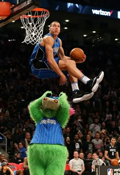 a man on a basketball court jumping in the air to dunk a ball at a game