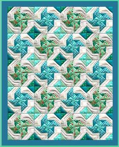 a blue and white quilt with an intricate design on the front, along with a green border