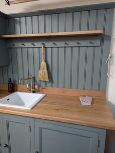 a kitchen sink sitting under a wooden shelf