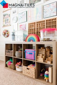 a shelf filled with lots of toys and other items next to a wall full of pictures