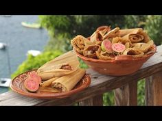 two plates filled with food sitting on top of a wooden deck next to water and boats