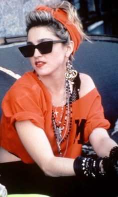 a woman in an orange shirt and black sunglasses