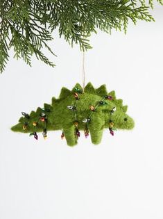 a green christmas ornament hanging from a tree