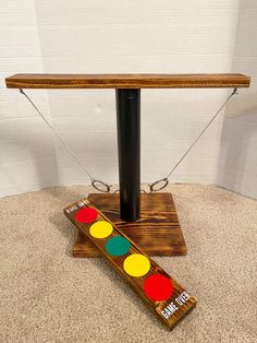 a wooden table with two different colored circles on it and a black pole holding the top