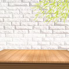 a wooden table in front of a white brick wall with a bamboo plant on it