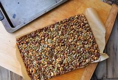 a wooden cutting board topped with lots of nuts