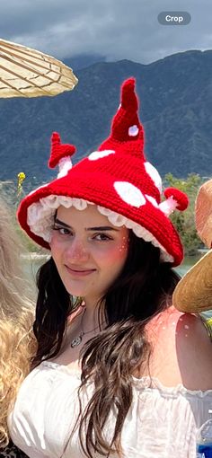 two girls wearing red and white knitted hats on their heads, with mountains in the background