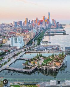 an aerial view of a large city and the water in front of it at sunset