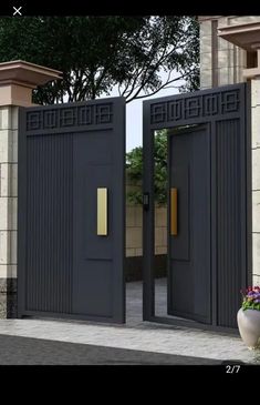 two black doors are open in front of a brick wall and potted planter