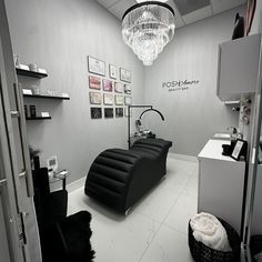 a salon with black and white furniture, chandelier and pictures on the wall