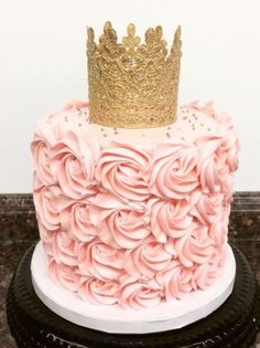 a pink and gold cake with a crown on top