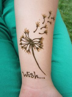 a woman's arm with a dandelion tattoo on it that says vein