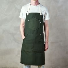 a man wearing an apron standing in front of a wall