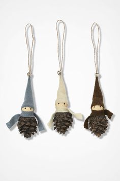 three christmas ornaments made from pine cones, one with a gnome and the other with a snowman