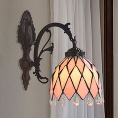 a light that is on the wall next to a window with curtains in front of it