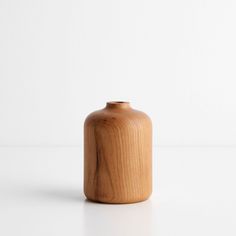 a wooden vase sitting on top of a white table