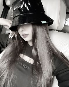 a woman wearing a black hat sitting in the back seat of a car with long hair