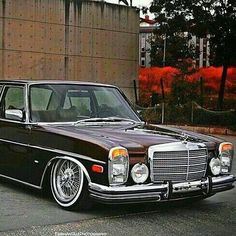 an old black car parked in front of a building