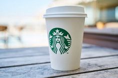 a starbucks cup sitting on top of a wooden table