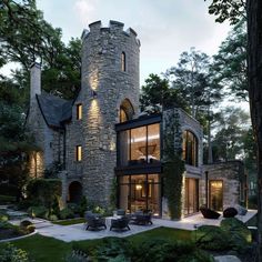 this is an image of a modern house in the woods at night time with lights on