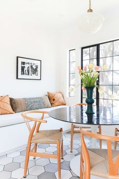 a living room filled with furniture next to a window covered in lots of windows and flowers