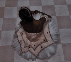 a woman in a white dress is sitting on the floor with her back to the camera