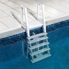 a white chair sitting on top of a step ladder next to a blue swimming pool