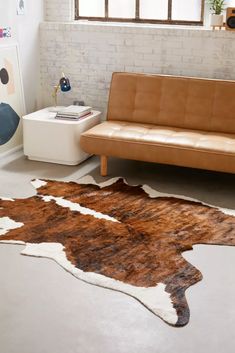 a brown and white cowhide rug in a living room