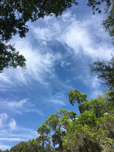 the sky is blue and white with some clouds in it, as well as trees