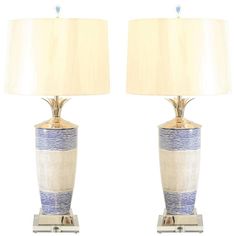 a pair of blue and white vases with lamps on each side, one is turned off