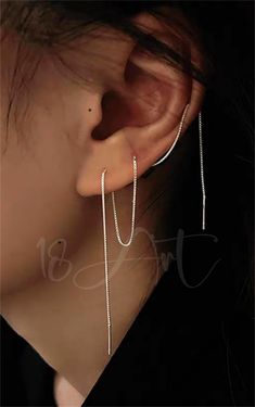 a woman's ear with two chains attached to it