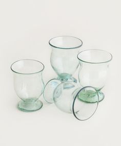 four glass cups are stacked on top of each other, with one empty cup in the middle